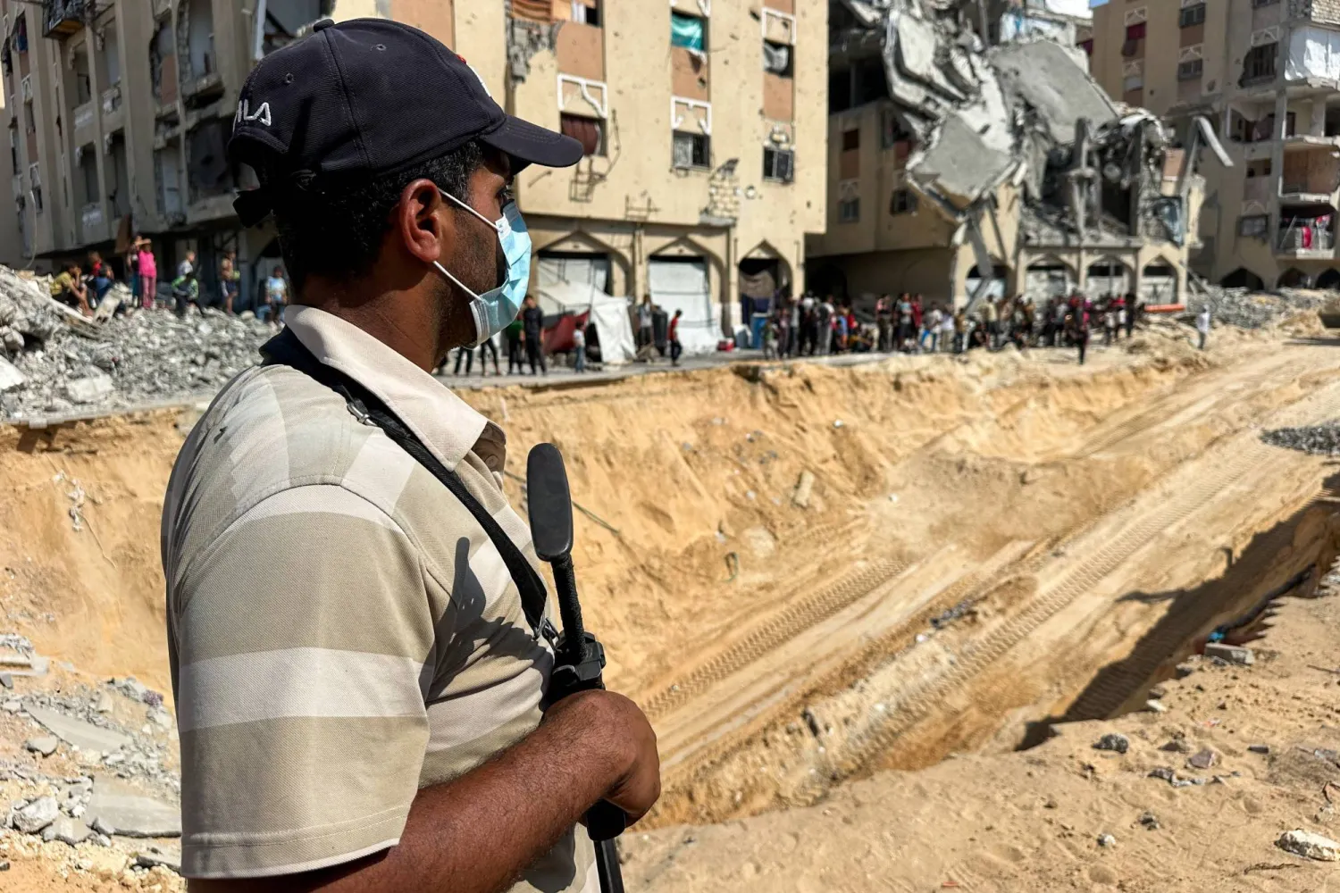 A Hamas militant stands guard near a site where searches are underway for the bodies of hostages killed after being seized by Hamas during the October 7, 2023 attack, in Khan Younis, southern Gaza Strip, October 17, 2025. REUTERS/Stringer