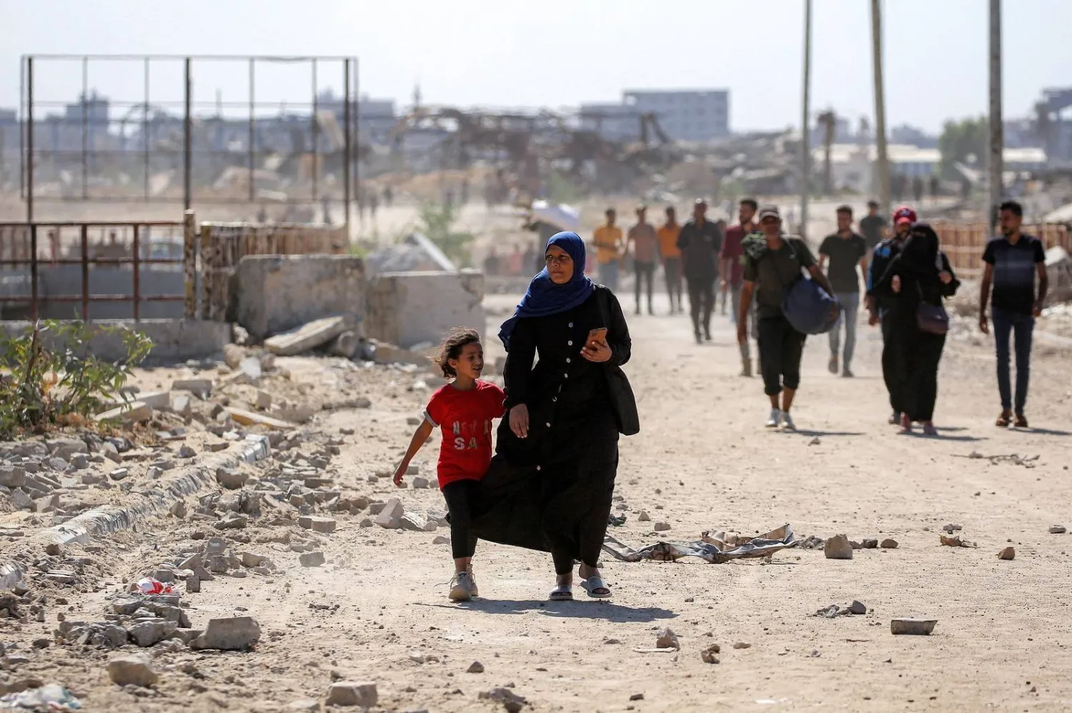 A woman and girl walk toward Gaza City through the Netzarim corridor near Nuseirat in central Gaza Strip (AFP)