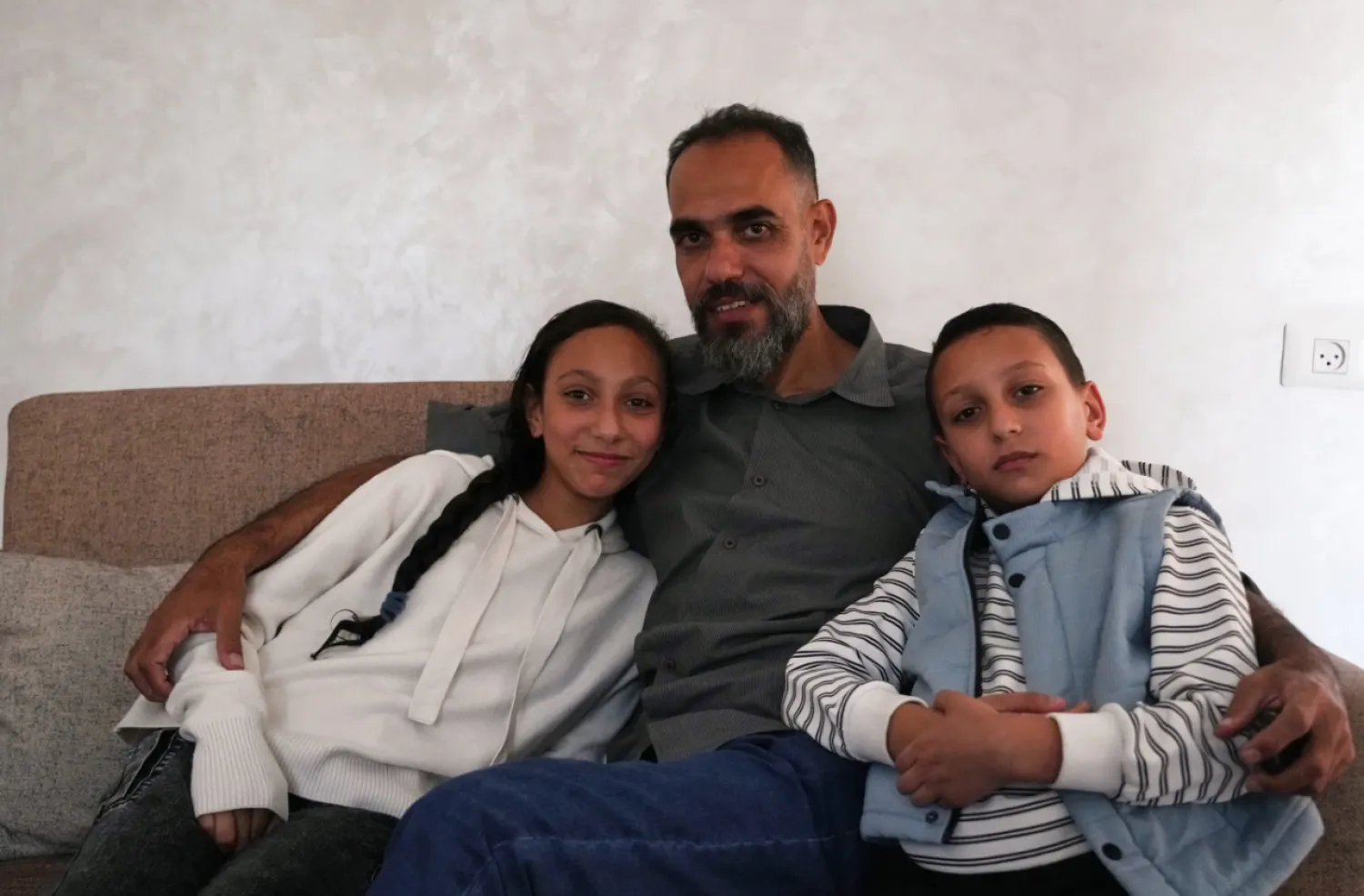 
Mohammed Abu Moussa, 45, who was released from Israeli detention after 20 months, poses for a photo with his children, Jourie and Hamid, in Deir al-Balah, Gaza, Saturday, Oct, 18, 2025. (AP Photo/Abdel Kareem Hana)