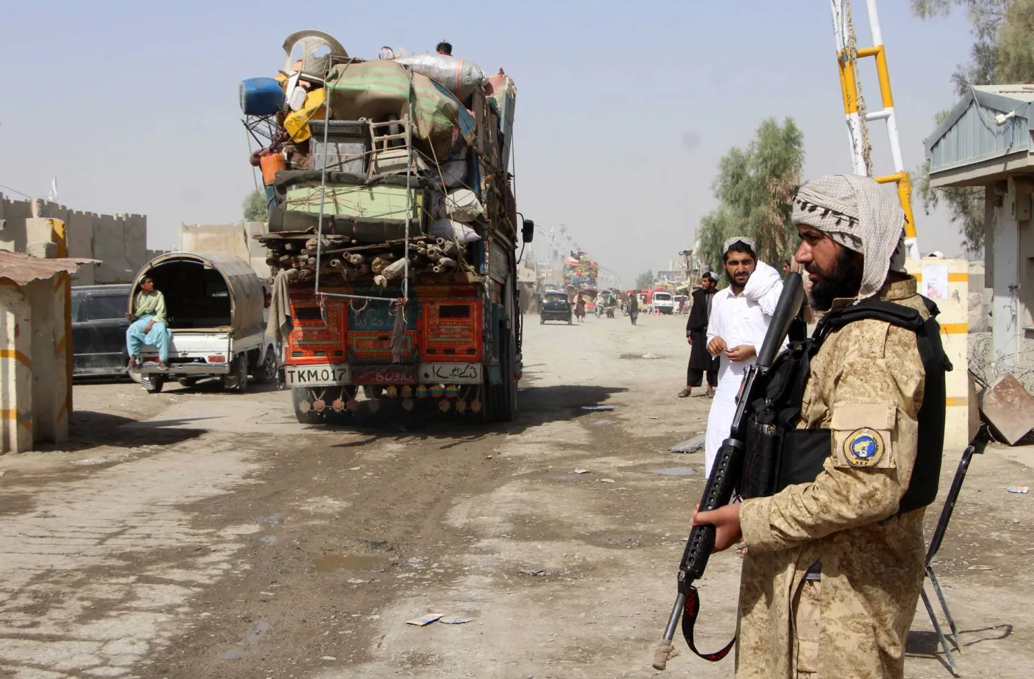 عناصر أمن أفغان يراقبون عودة مواطنيهم إلى إقليم سبين بولداك عقب فتح المعبر الحدودي في قندهار - 19 أكتوبر (إ.ب.أ)