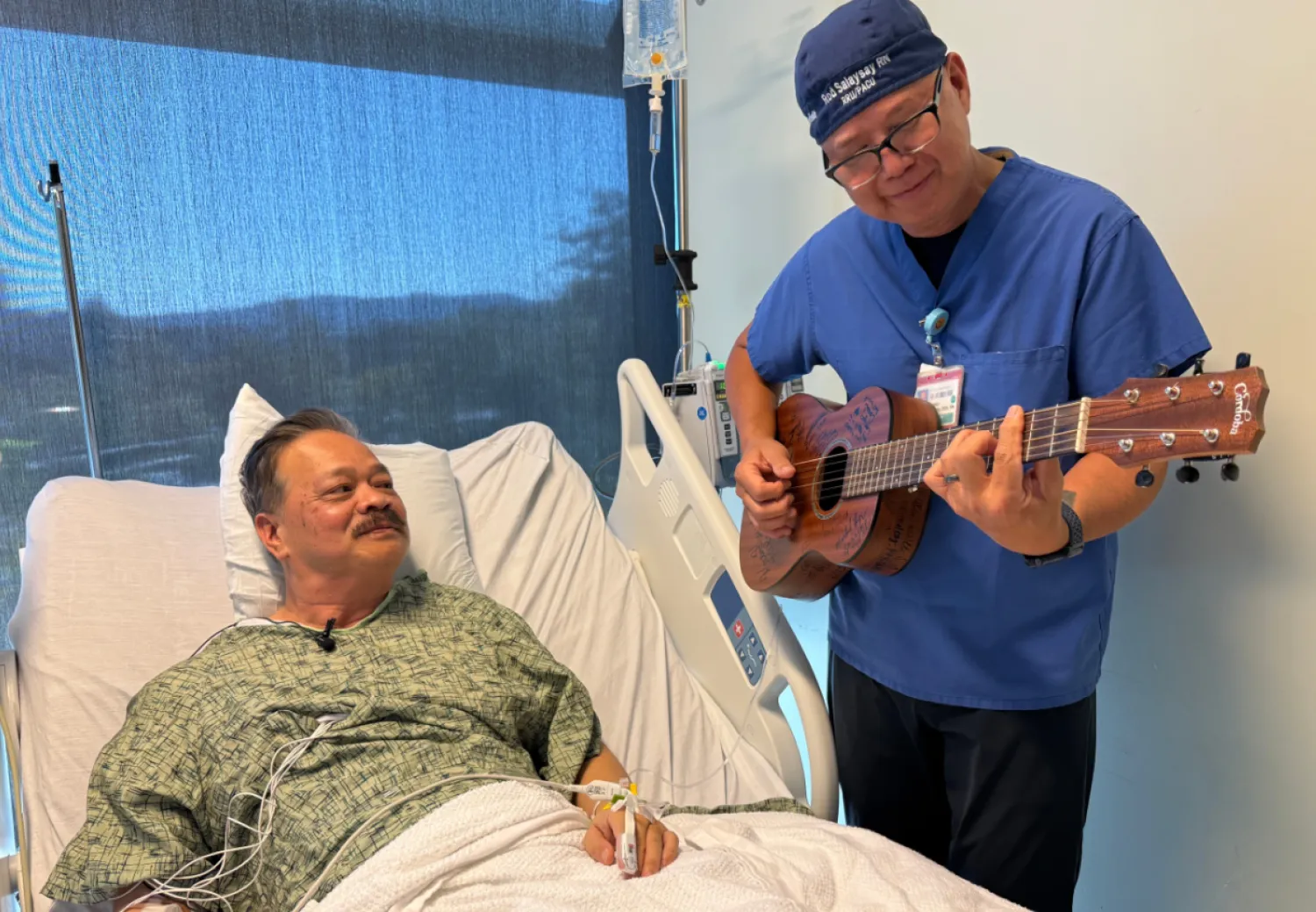 Nurse Rod Salaysay plays guitar for patient Richard Hoang in the recovery unit of UC San Diego Health in San Diego, Calif., on Sept. 30, 2025. (AP Photo/Javier Arciga)