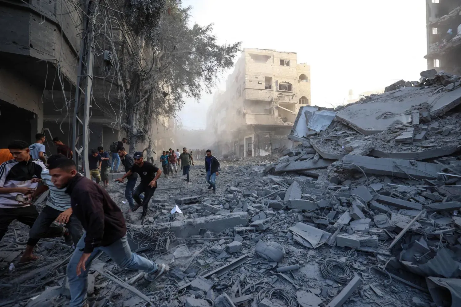 Dün Gazze Şeridi’nin el-Bureyc Mülteci Kampı’nda İsrail tarafından saldırı düzenlenen bir bölgeden kaçmaya çalışan Filistinliler (AFP)