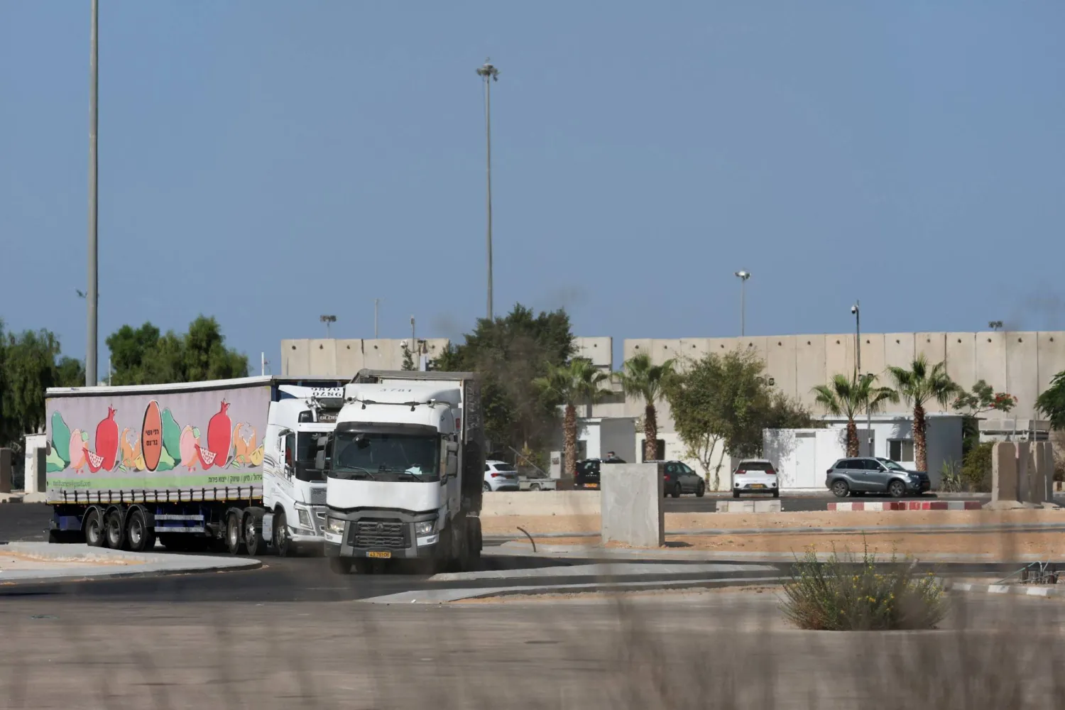 شاحنات تحمل مساعدات تنتظر على الجانب الإسرائيلي من معبر كرم أبو سالم الحدودي إلى جنوب غزة (رويترز)