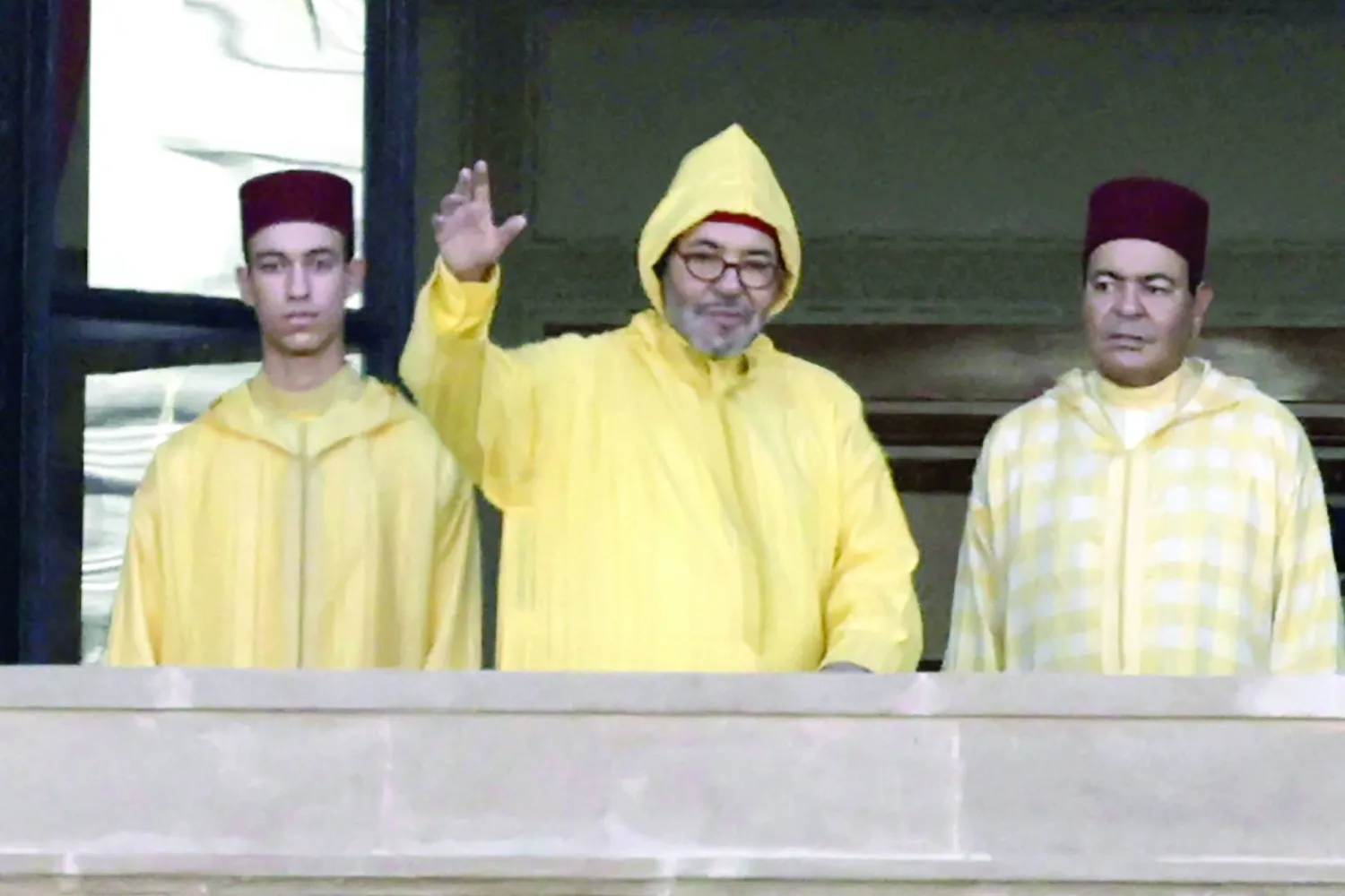 العاهل المغربي لدى وصوله إلى شرفة البرلمان في 10 أكتوبر رفقة ولي العهد مولاي الحسن وشقيقه الأمير مولاي رشيد (أ.ف.ب)