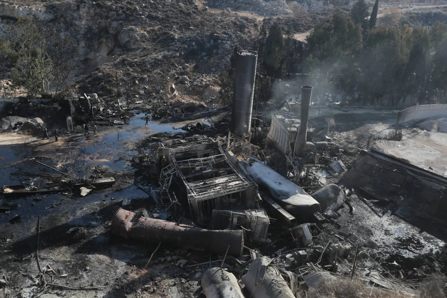 أشخاص يتفقدون الأضرار التي لحقت بمصنع للأسمنت بسبب الغارات الجوية الإسرائيلية على قرية أنصار بجنوب لبنان الجمعة (أرشيفية - أ.ب)