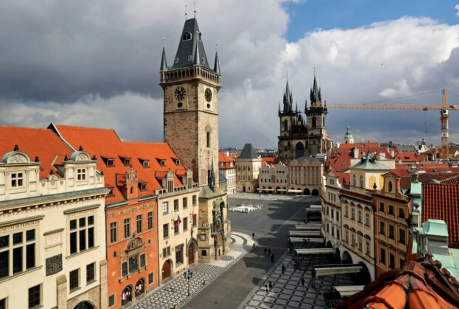 A clock showing the time at noon is pictured on a building, next to almost empty streets at Old Town Square during the coronavirus disease (COVID-19) outbreak, in Prague, Czech Republic, March 31, 2020. REUTERS/David W Cerny 