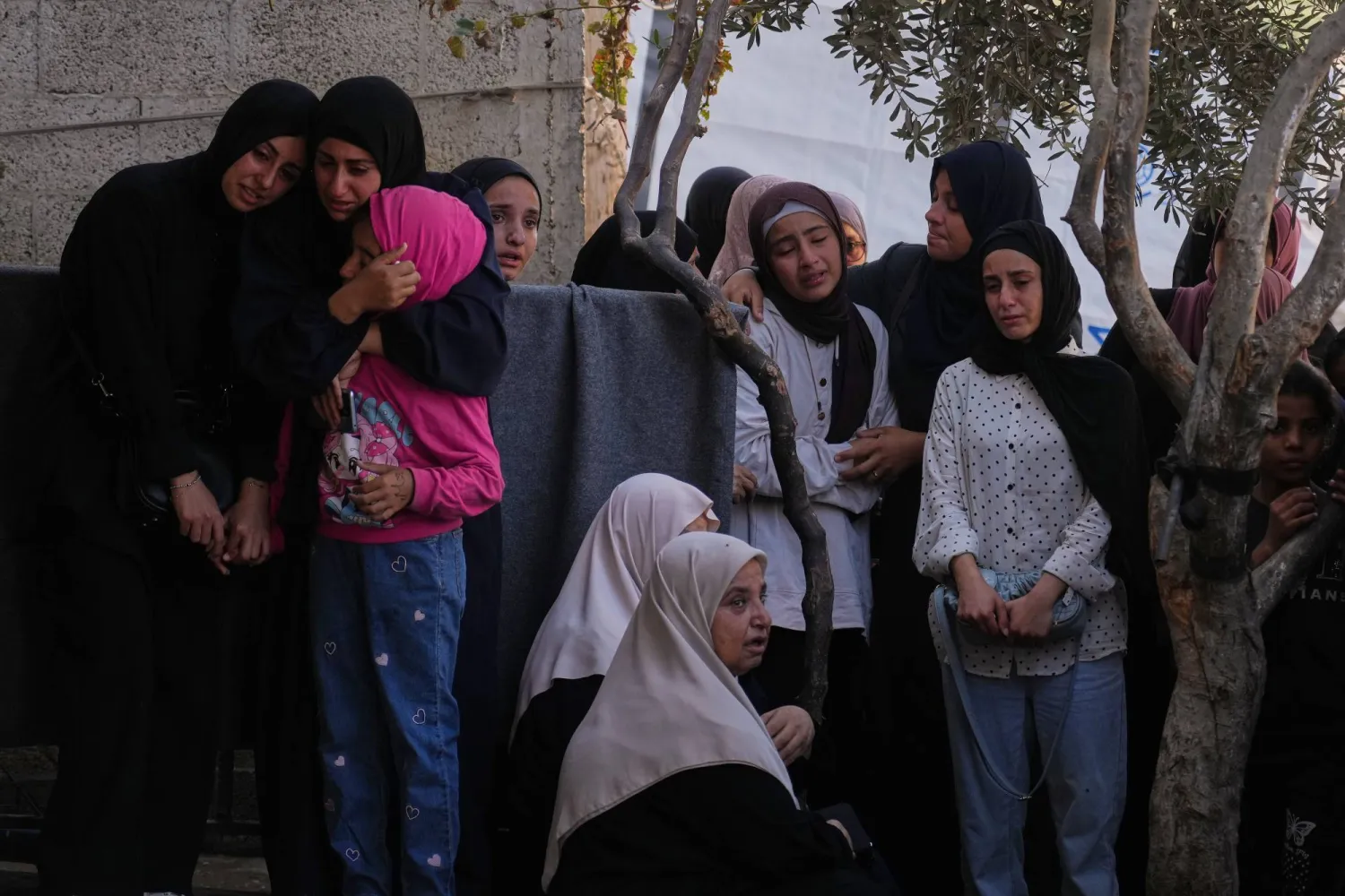 فلسطينيون خلال تشييع جثامين قتلى قصف إسرائيلي يصطفون في مستشفى وسط قطاع غزة يوم الاثنين (أ.ب)