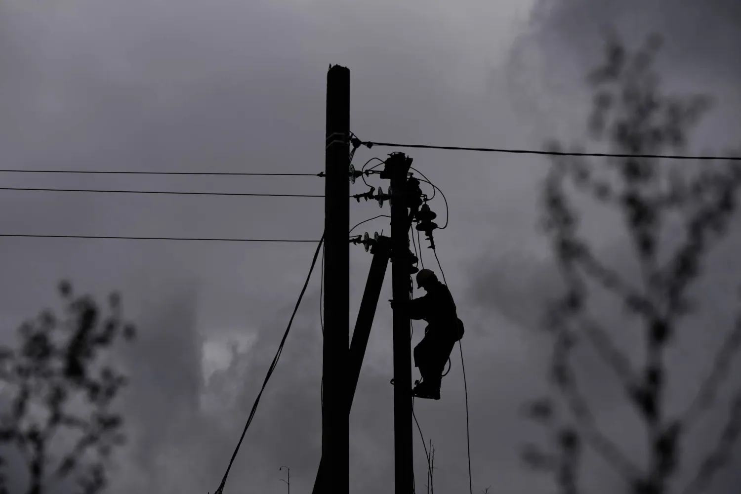 A worker climbs a utility pole while repairing power lines damaged in a Russian attack, Thursday, Oct. 16, 2025, in Shostka, Ukraine. (AP)
