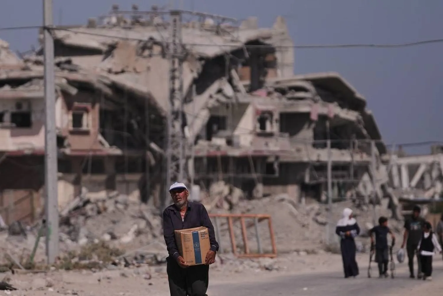 A Palestinian man carries a box of food from the World Food Program (WFP) after collecting it in Khan Younis, in the southern Gaza Strip, Monday, Oct. 20, 2025. (AP)