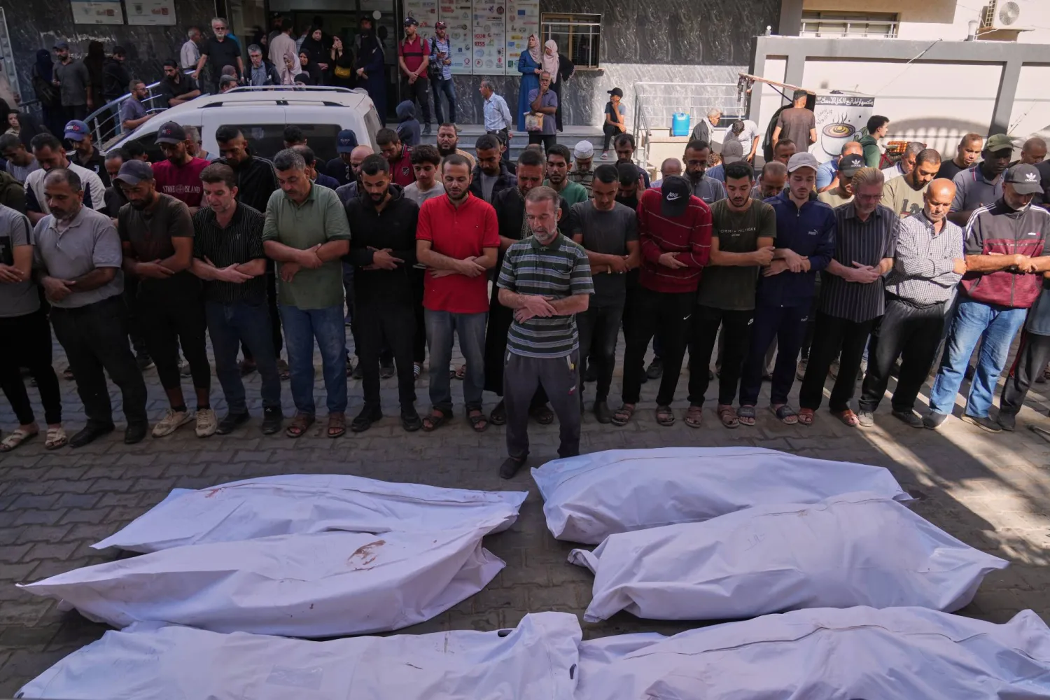 فلسطينيون يصلون على جثامين الشهداء الذين سقطوا بغارة عسكرية إسرائيلية الأحد خلال تشييعهم في مستشفى عودة بالنصيرات وسط قطاع غزة (أ.ب)