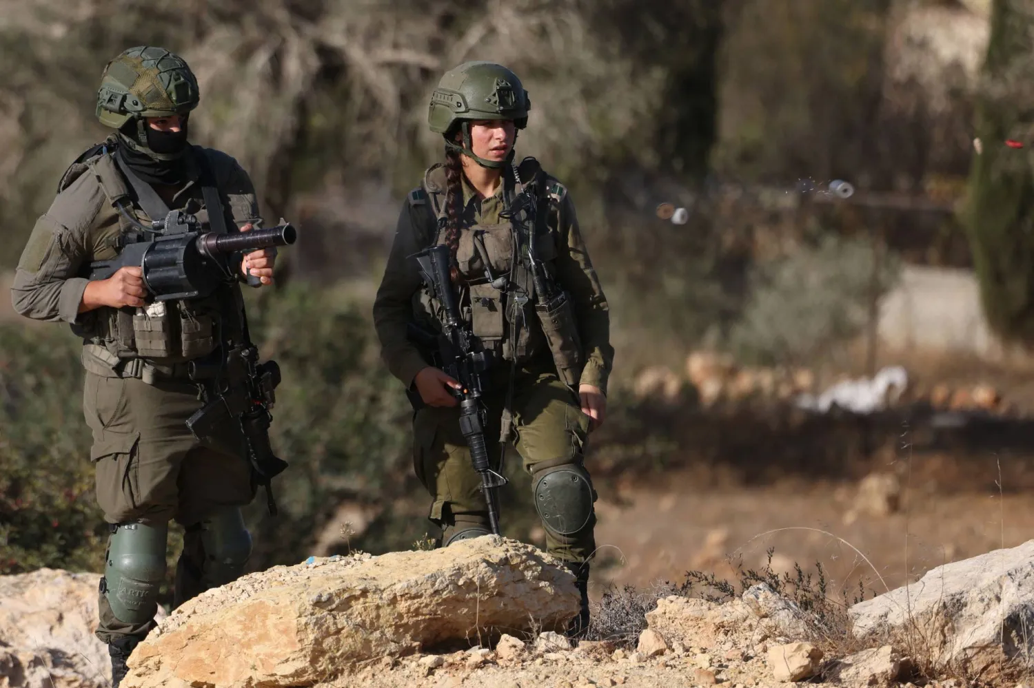 قوات الأمن الإسرائيلية تُطلق الغاز المسيل للدموع لمنع الفلسطينيين من الوصول إلى أراضيهم لجمع الزيتون بالقرب من رام الله في الضفة الغربية (أ.ف.ب)