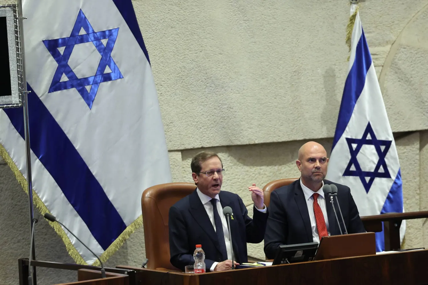 الرئيس الإسرائيلي إسحاق هرتسوغ (يسار) يلقي كلمة في افتتاح الدورة الشتوية للكنيست في القدس يوم الاثنين (إ.ب.أ)