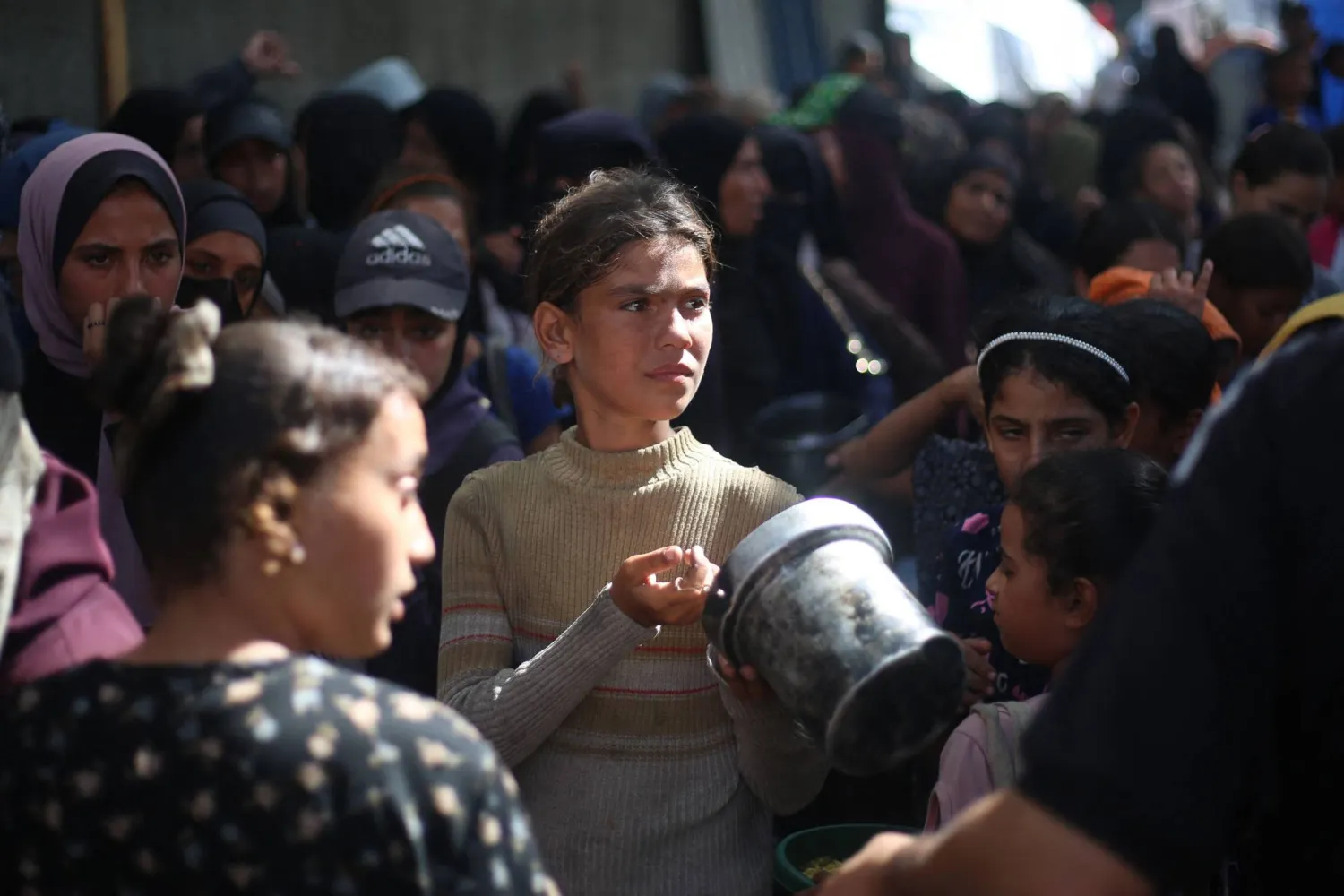 نازحون فلسطينيون ينتظرون تلقي المساعدات الغذائية في مخيم النصيرات وسط غزة يوم الثلاثاء (أ.ف.ب)