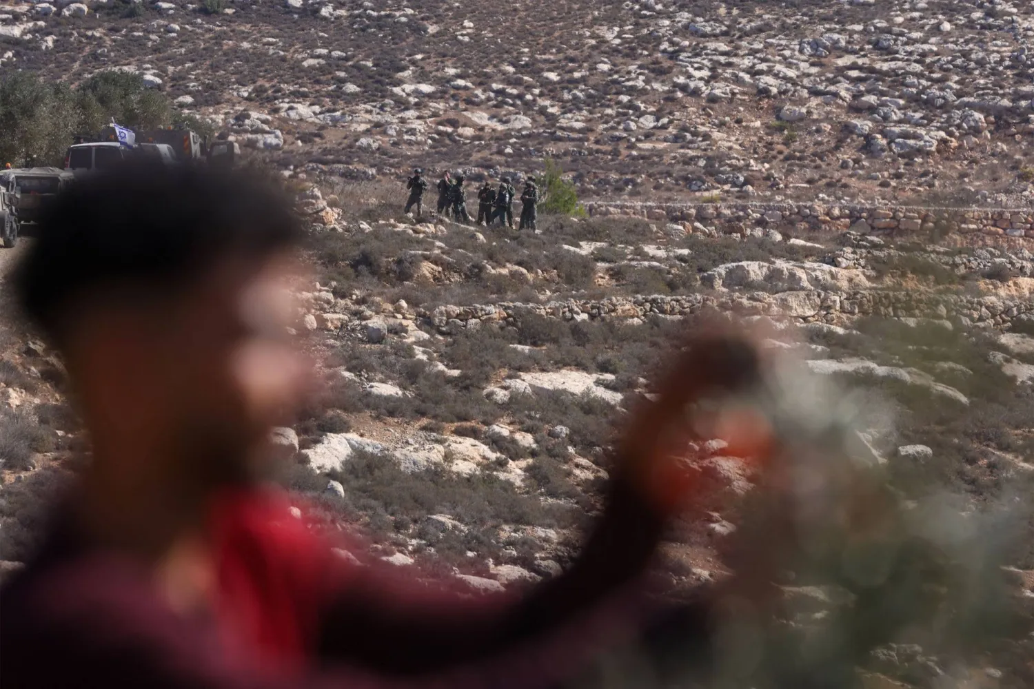 Israeli soldiers take position as Palestinians harvest olives in the occupied West Bank village of Turmus Ayya, on the outskirts of Ramallah, on October 20, 2025. (AFP)