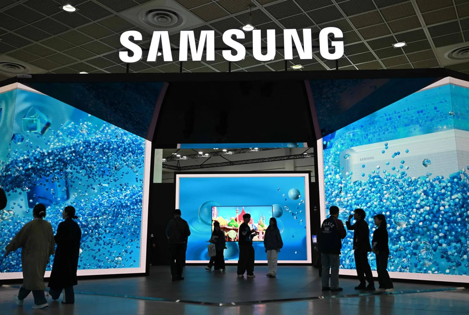 Visitors walk past the Samsung Electronics booth during the Korea Electronics Show 2025 at the COEX convention and exhibition center in Seoul on October 22, 2025. (AFP)