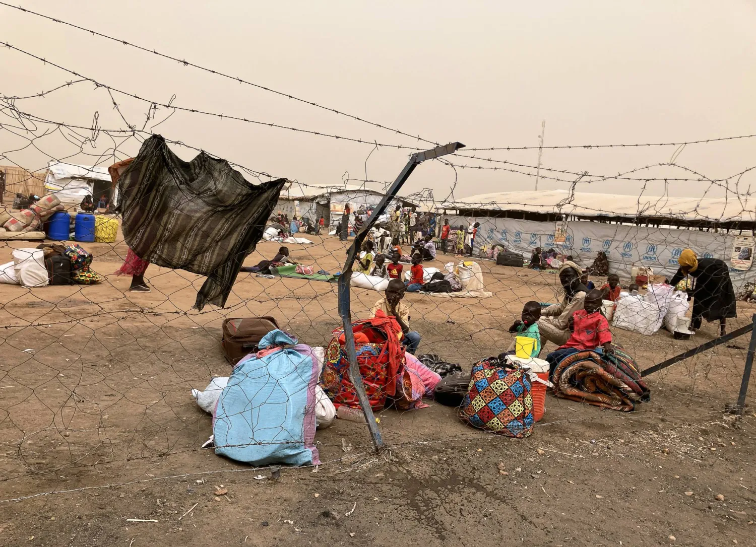 19 March 2024, South Sudan, Joda: Refugees from Sudan wait behind the border crossing into South Sudan to continue their journey. (dpa)