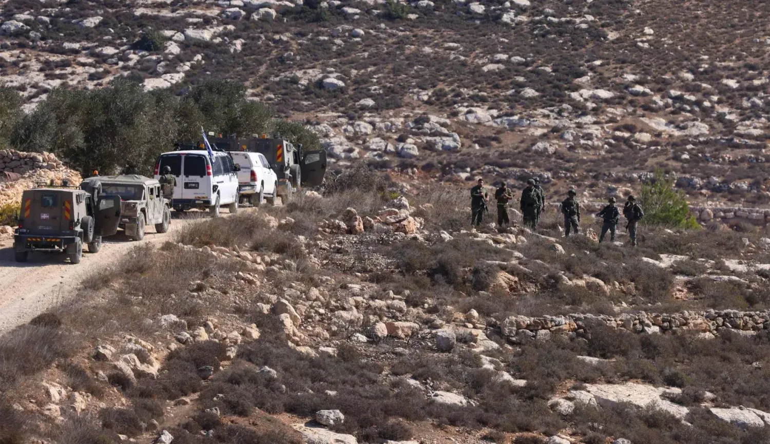 İsrail askerleri, Filistinlilerin geçen pazartesi günü zeytin hasadını yaptığı Ramallah'ın dışındaki bir köyde nöbet tutuyor (AFP)