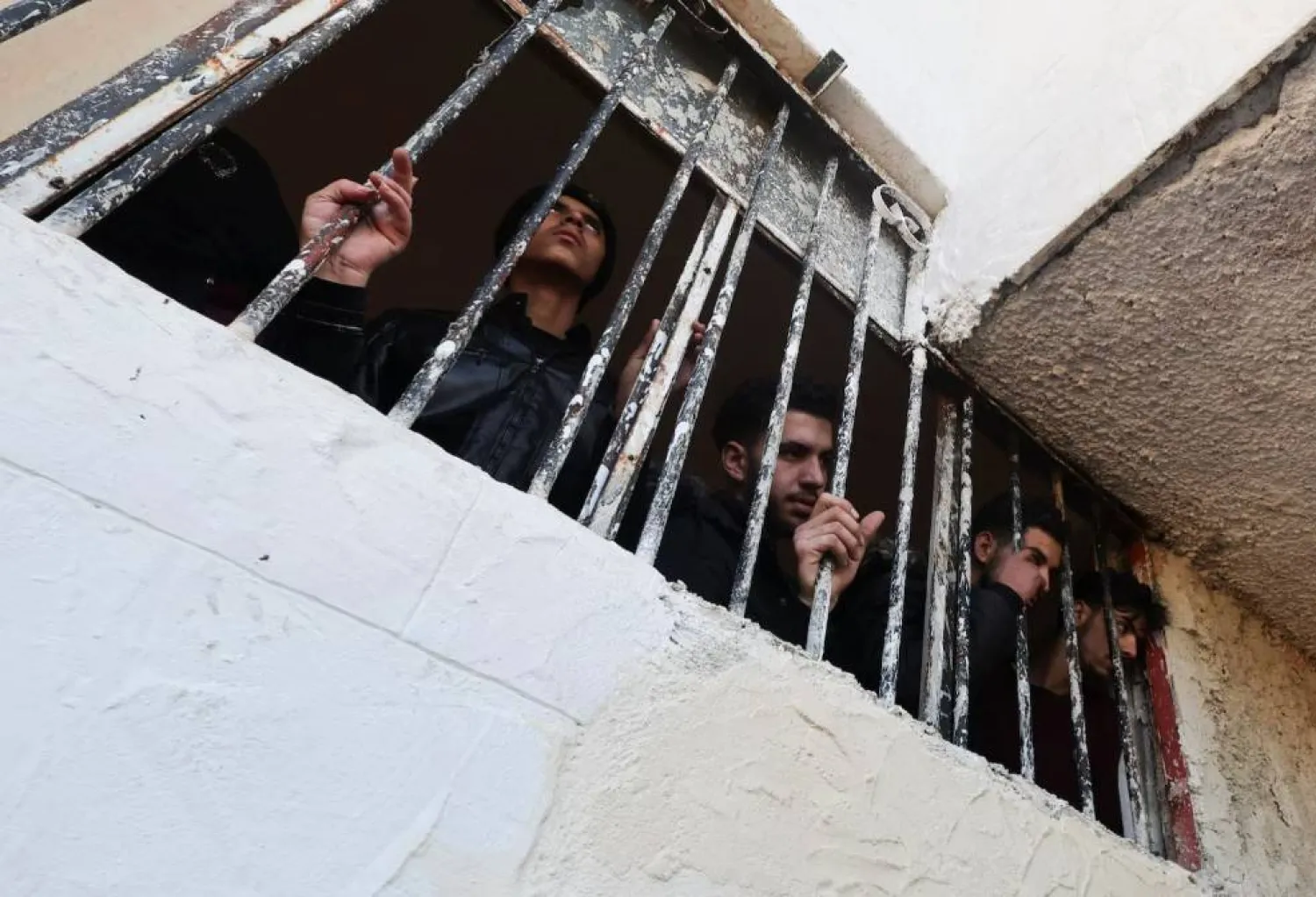 أشخاص يراقبون بينما يقوم عناصر بالبحث عن سجناء تحت الأرض في سجن صيدنايا ديسمبر 2024 (أرشيفية - رويترز)