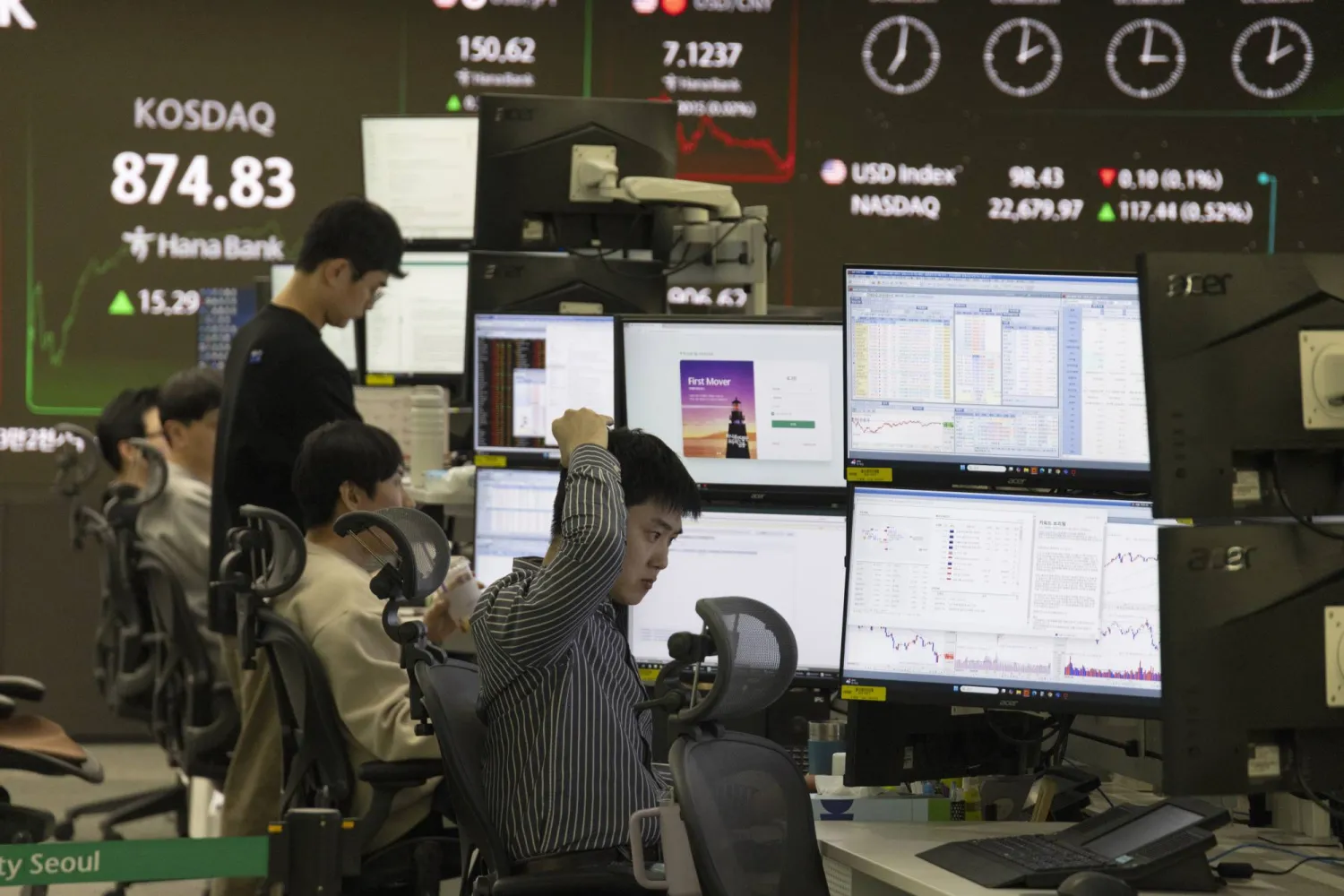 متداولون يعملون أمام شاشات تعرض مؤشرات الأسهم في بنك هانا في سيول (إ.ب.أ)