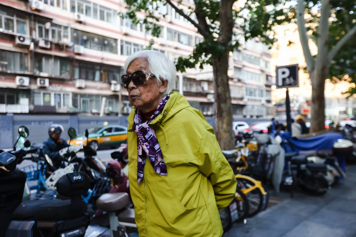 امرأة مسنة تمشي في أحد شوارع بكين (إ.ب.أ)