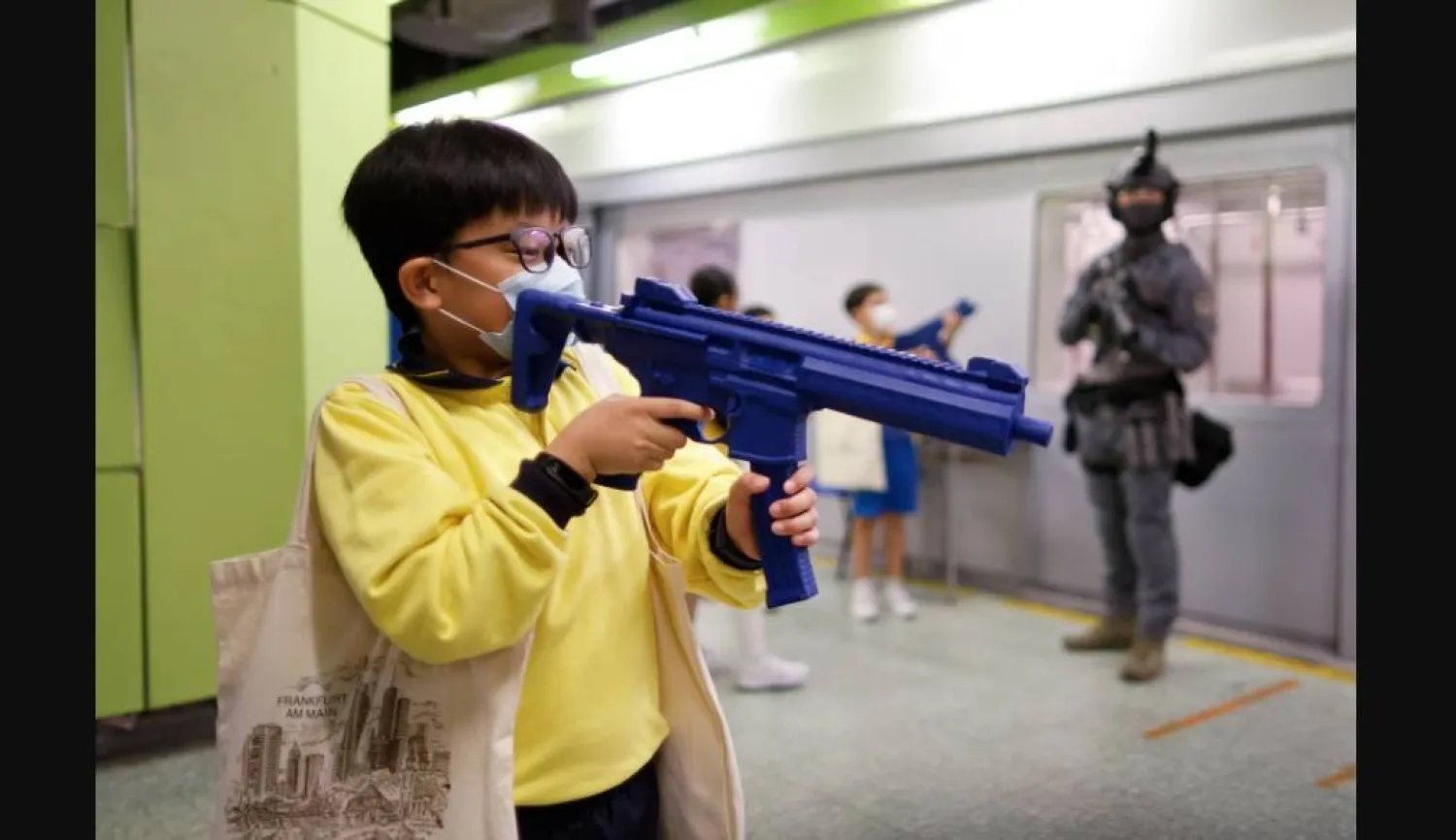 طفل يحمل لعبة على شكل بندقية (رويترز)