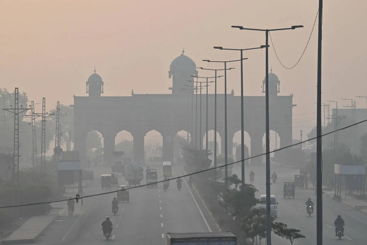 يتنقل الركاب على طول الطريق وسط ظروف ضبابية في لاهور 24 أكتوبر 2025 (أ.ف.ب)