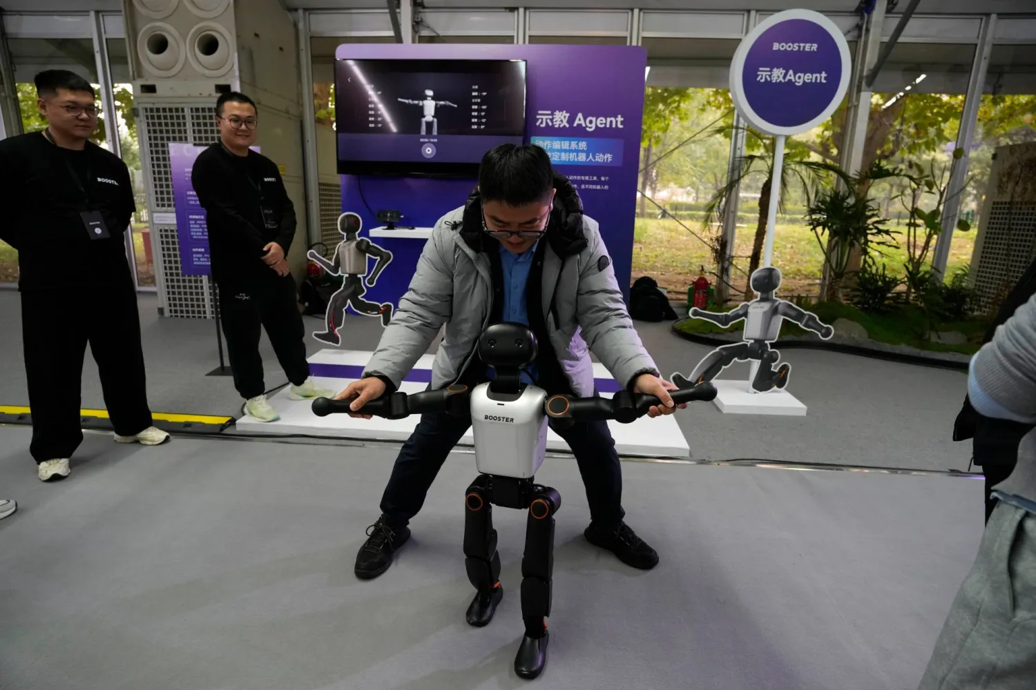 رجل يستعرض روبوتاً خلال زيارته لمعرض تقني في العاصمة الصينية بكين (أ.ب)