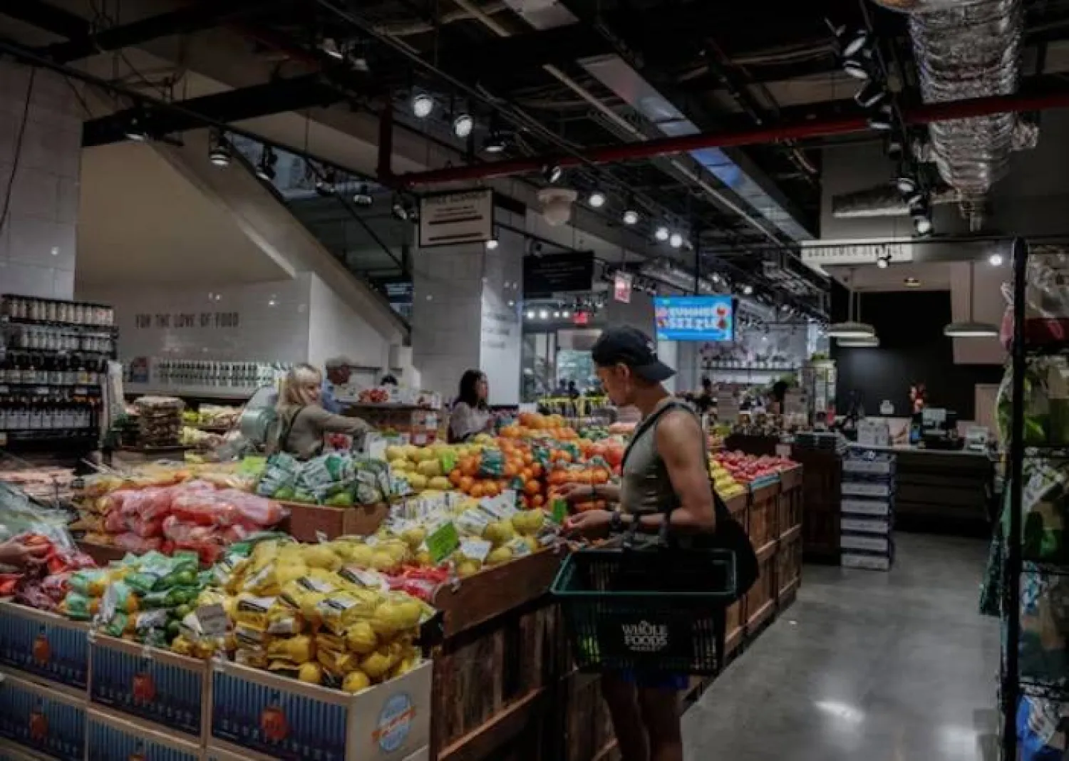 يتسوق أشخاص لشراء البقالة في متجر بمدينة نيويورك (رويترز)