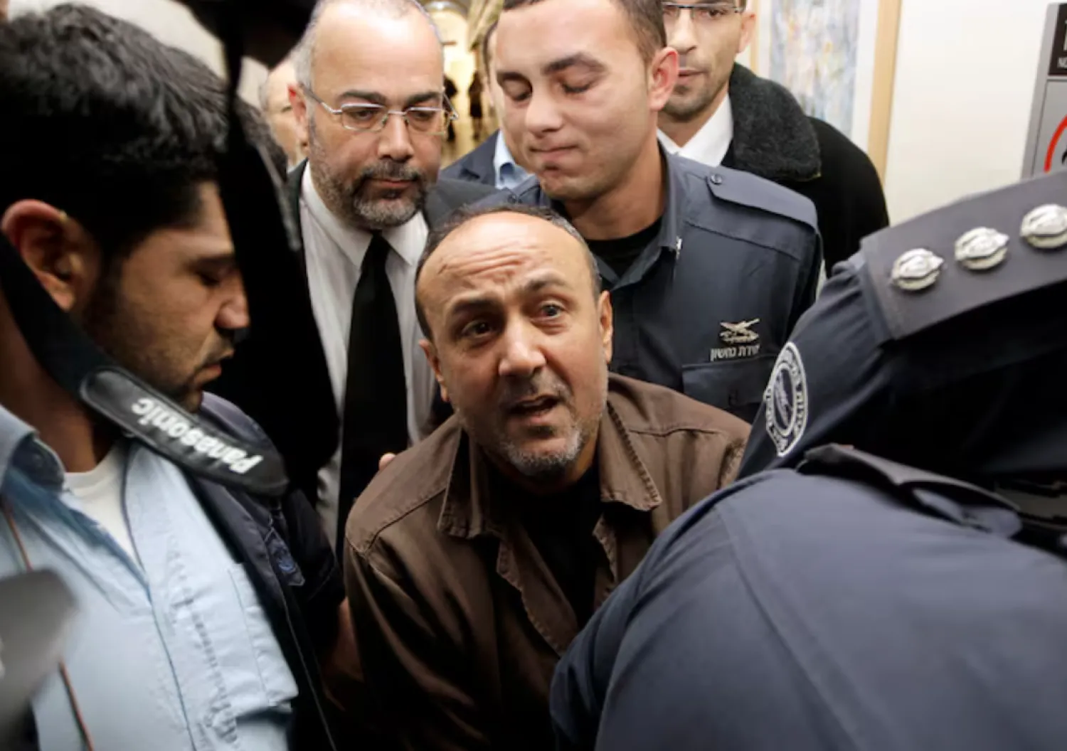 Jailed Fatah leader Marwan Barghouti (C) is accompanied by Israeli prison guards after a deliberation at Jerusalem Magistrate's court January 25, 2012. Convicted of murder for his role in attacks on Israelis, Barghouti was jailed for life by Israel in 2004. REUTERS/Ammar Awad/File Photo 