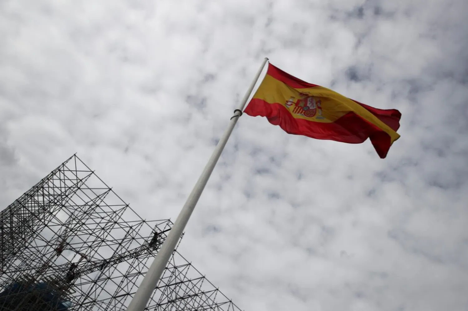 Workers set up a huge scaffold as a Spanish flag flutters at the Colon square in Madrid, Spain, November 2, 2021. REUTERS/Sergio Perez 