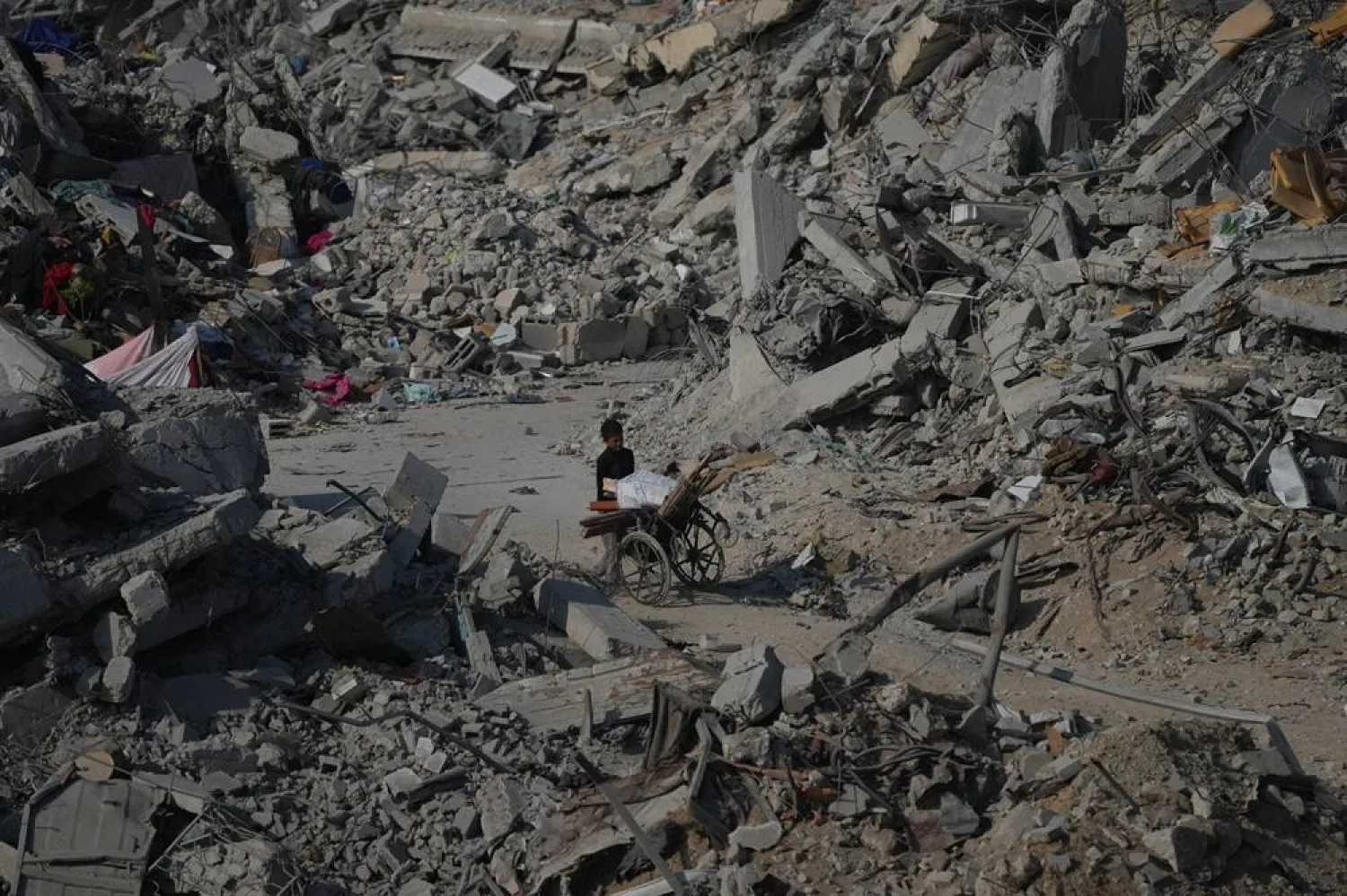 A boy pushes a wheelchair through the rubble of buildings destroyed in the war between Israel and Hamas, in the al-Nafaq area of the Sheikh Radwan neighborhood in Gaza City, Friday, Oct. 24, 2025. (AP) 