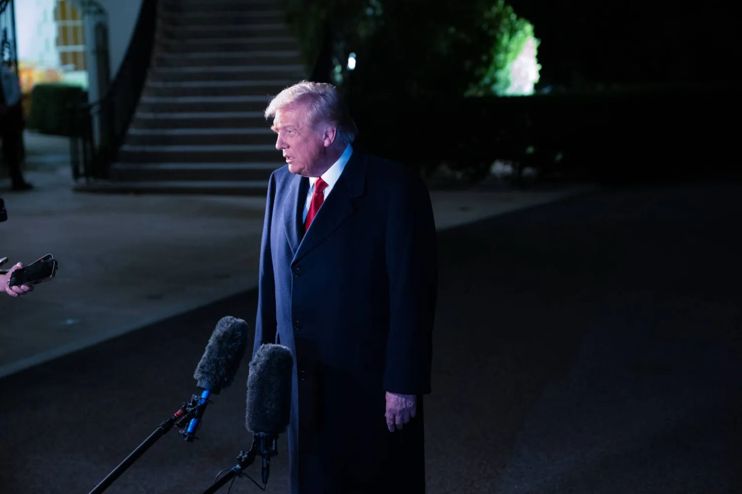 ترمب يُشير بيده أثناء حديثه إلى وسائل الإعلام قبل صعوده على متن الطائرة في طريقه إلى ماليزيا (د.ب.أ)