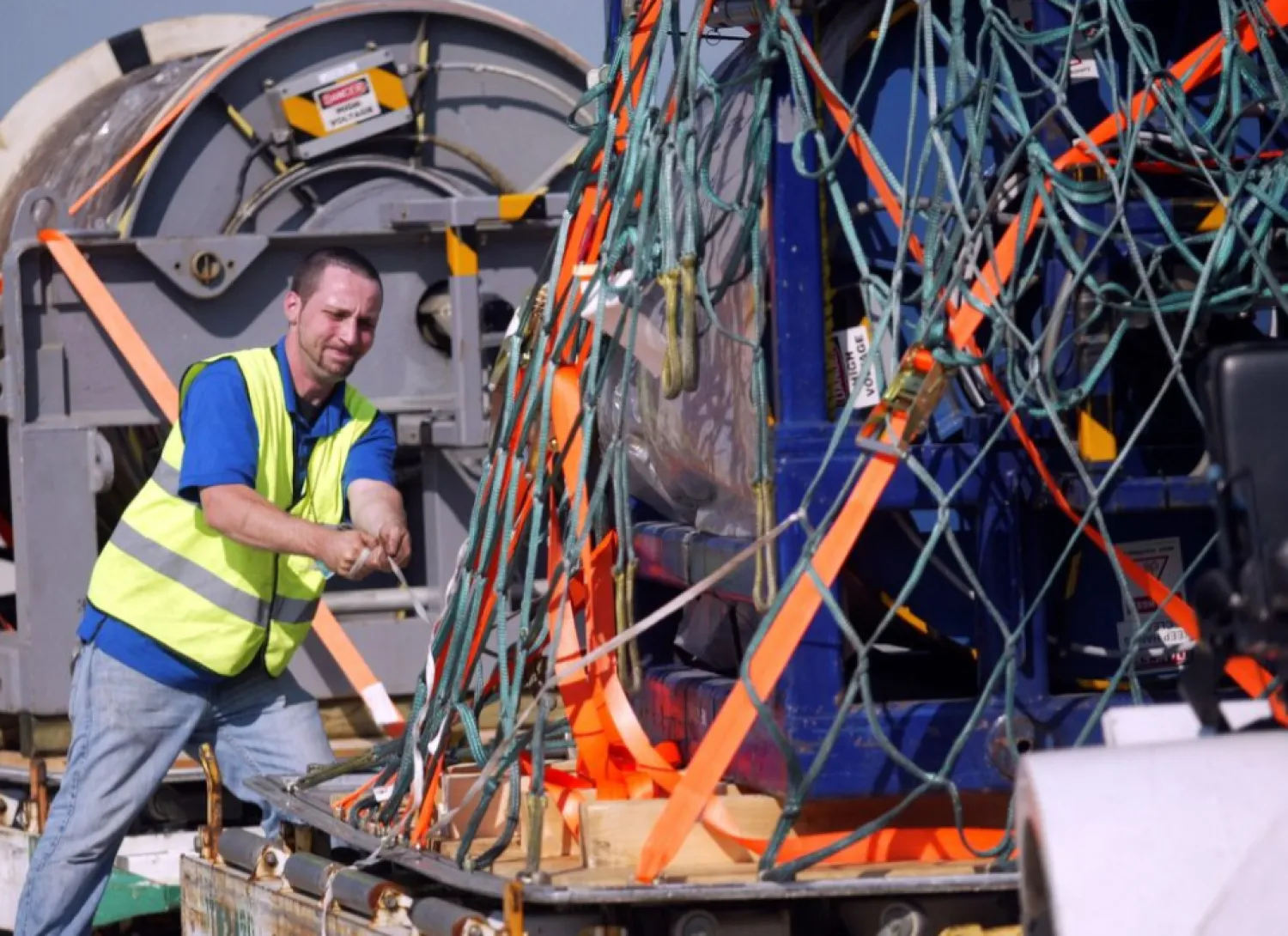File: Kevin Pollard ties down a 15,000-pound undersea cable for transportation at Dulles International Airport in Virginia, June 8, 2009. REUTERS