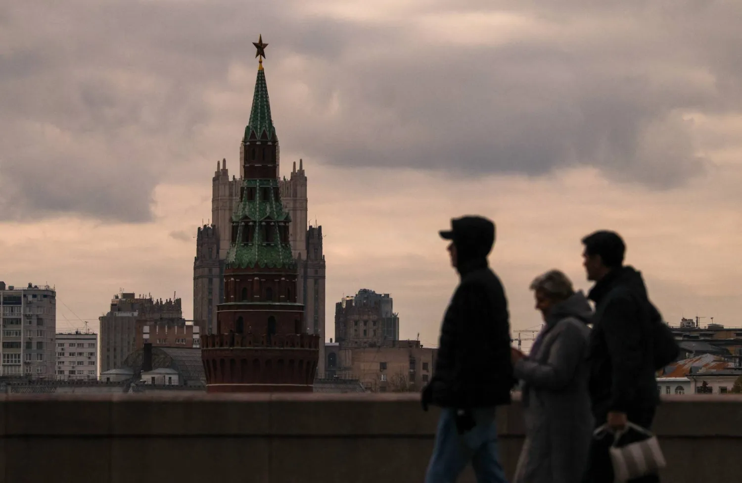 People walk across a bridge near a tower of the Kremlin in central Moscow, Russia, October 23, 2025. REUTERS/Ramil Sitdikov