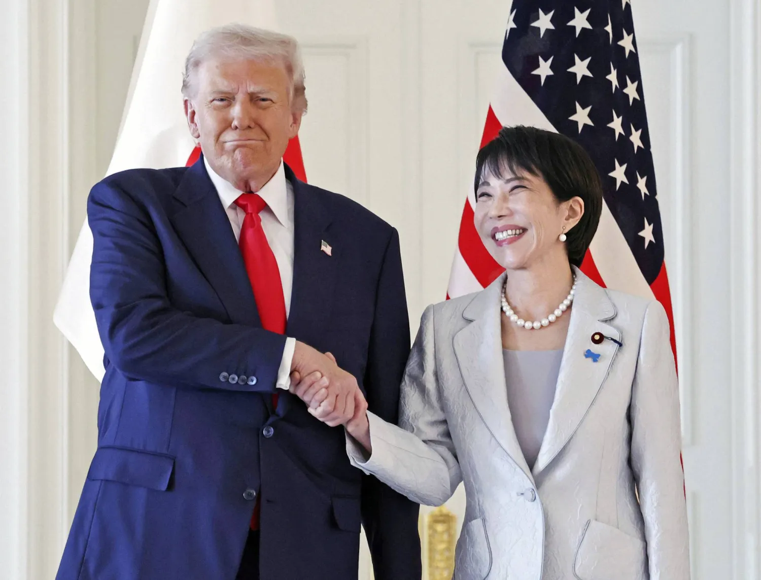 President Donald Trump, left, and Japanese Prime Minister Sanae Takaichi shake hands before their summit talk at Akasaka Palace in Tokyo, Tuesday, Oct. 28, 2025. (Kyodo News via AP)
