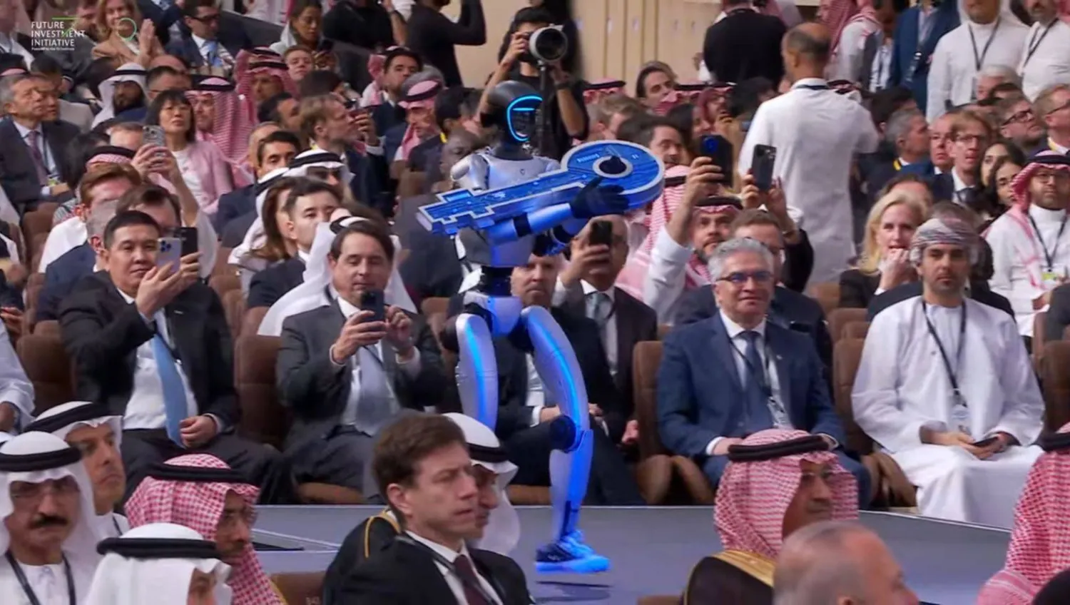 روبوت ذكي يحمل «مفتاح الازدهار» في بداية افتتاح مؤتمر «مبادرة مستقبل الازدهار» (الشرق الأوسط)