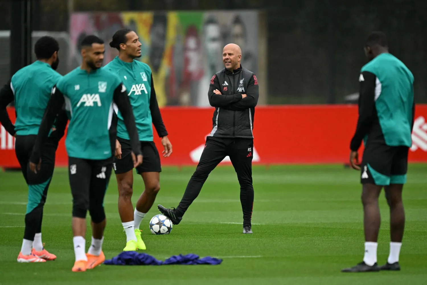 سلوت مدرب ليفربول يراقب لاعبيه خلال التدريبات بحثا عن حلول للخروج من الأزمة (ا ف ب)