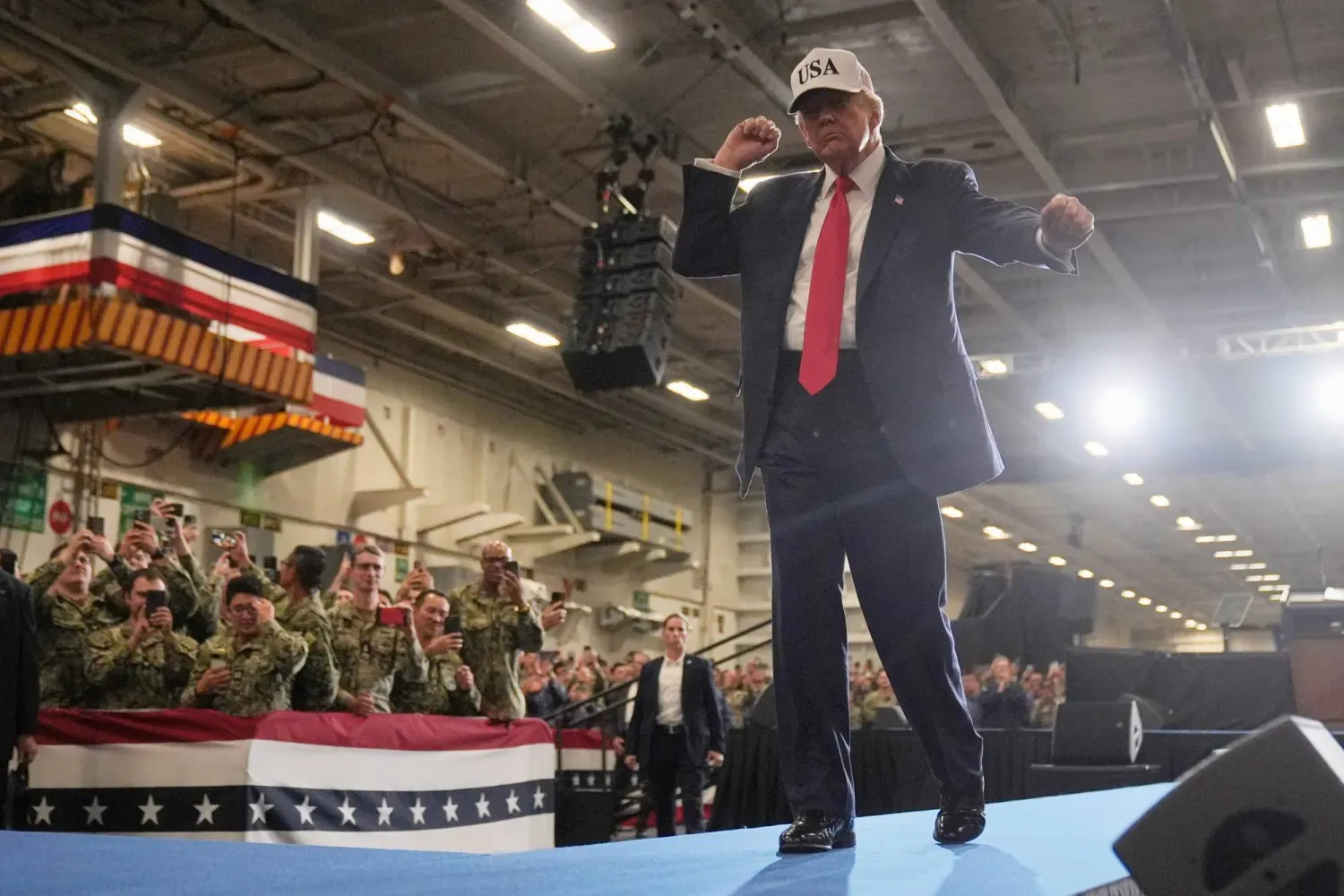 ABD Başkanı Donald Trump, Tokyo'nun güneyinde USS George Washington uçak gemisinde askerlere hitap ettikten sonra sahneden iniyor (AP)