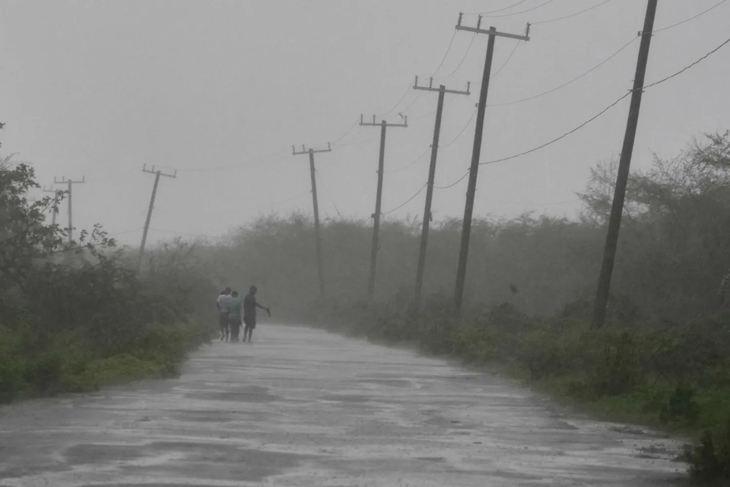 People walk along a road during the passing of Hurricane Melissa in Rocky Point, Jamaica, Tuesday, Oct. 28, 2025. (AP)