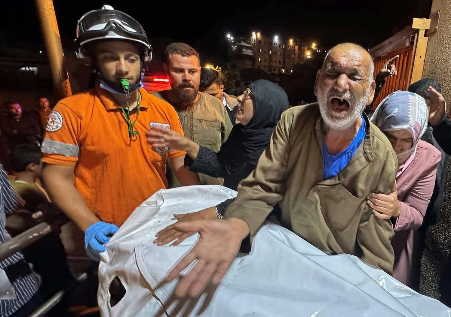 A Palestinian man reacts next to the body of a man, who according to medics was killed in an Israeli strike earlier today, at Nasser Hospital in Khan Younis, southern Gaza Strip, October 28, 2025. REUTERS/Stringer