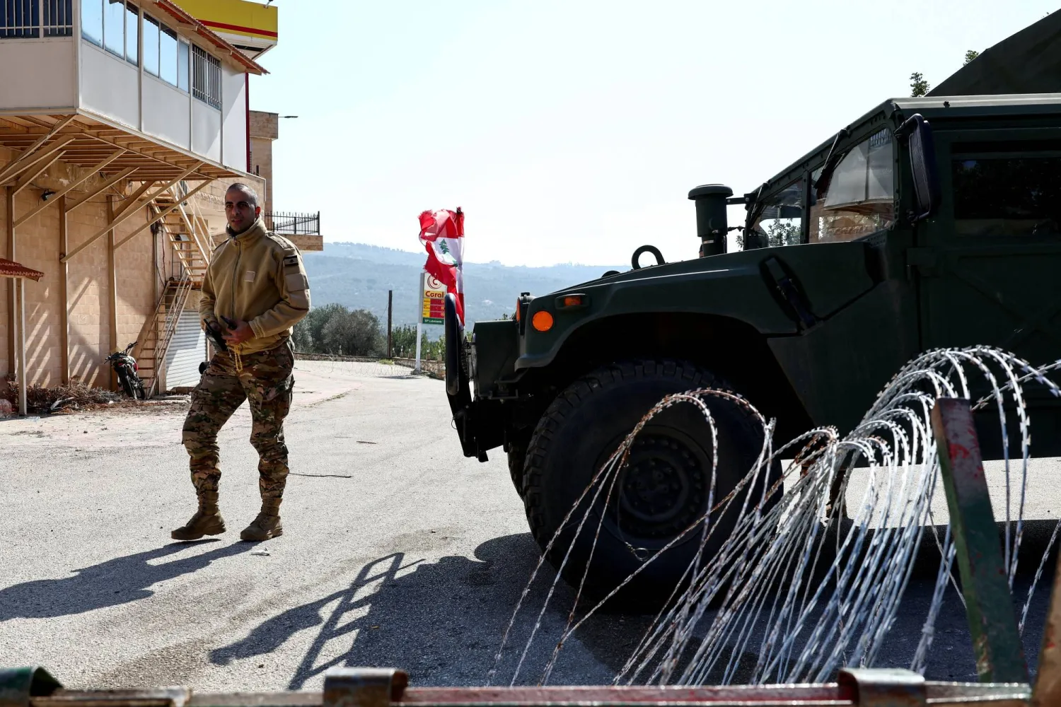 عنصر بالجيش اللبناني إلى جانب آلية عسكرية في بلدة ديرميماس جنوب لبنان فبراير 2025 (أرشيفية - رويترز)
