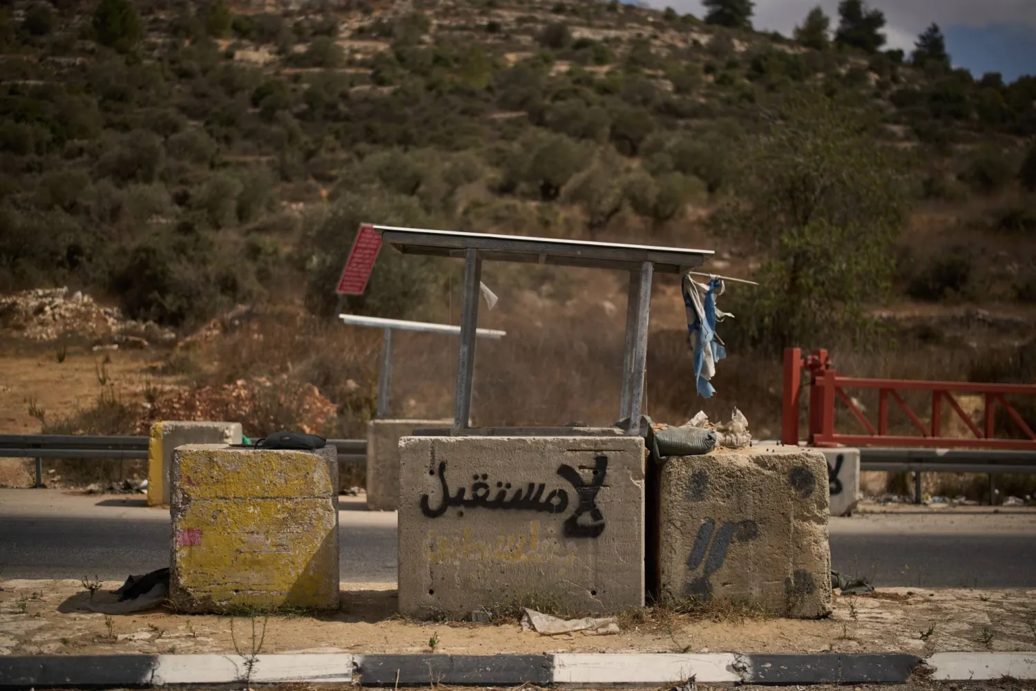 «لا مستقبل» مكتوبة باللغة العربية على كتلة خرسانية يستخدمها جنود إسرائيليون لحراسة وتفتيش السيارات على طريق بالقرب من قرية عين سينيا بالضفة الغربية (أ.ب)