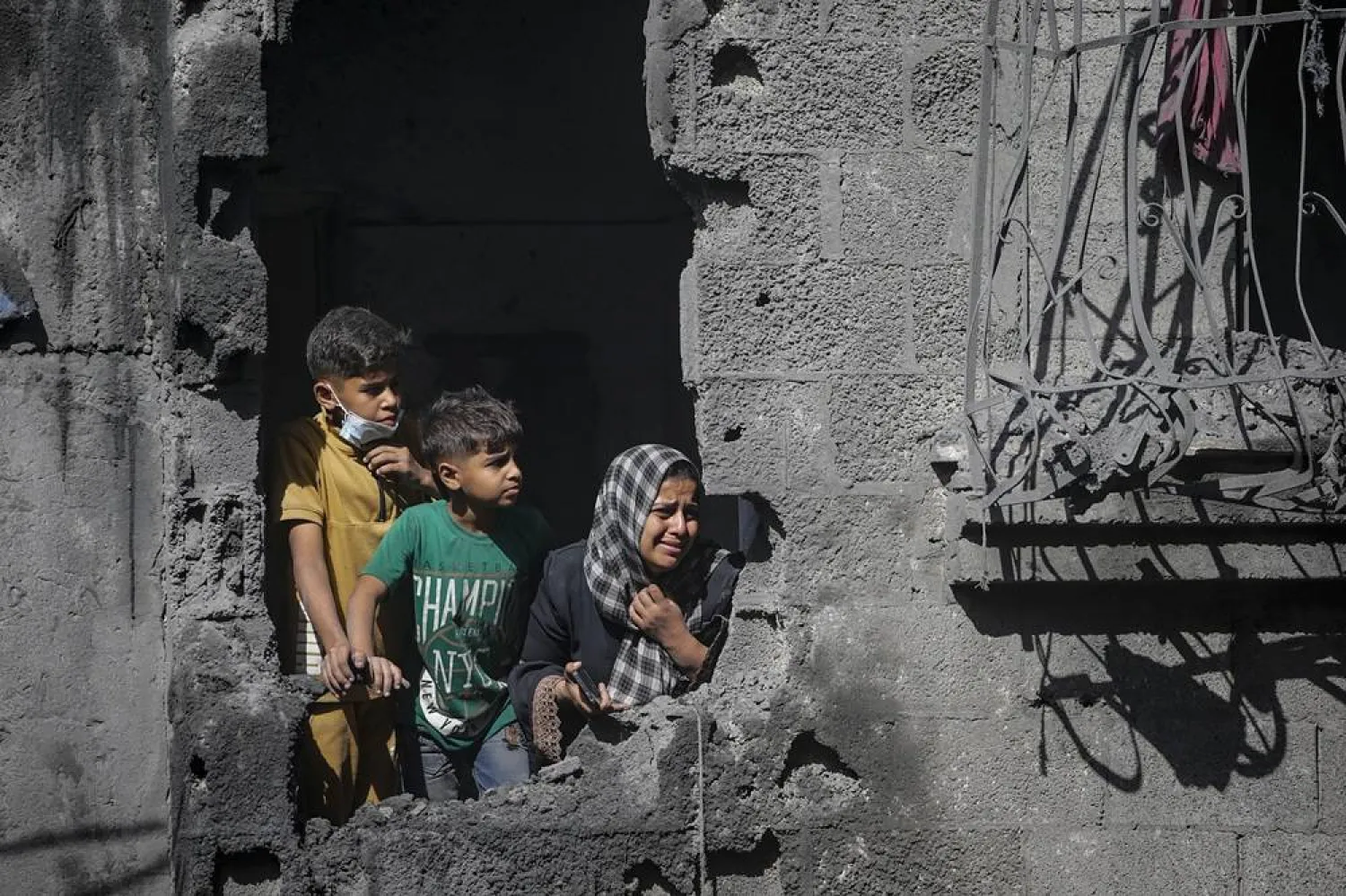 Palestinian children look out from their family's destroyed house following an Israeli airstrike targeting a residential block in Al Shatea refugee camp in Gaza City, 29 October 2025. (EPA)