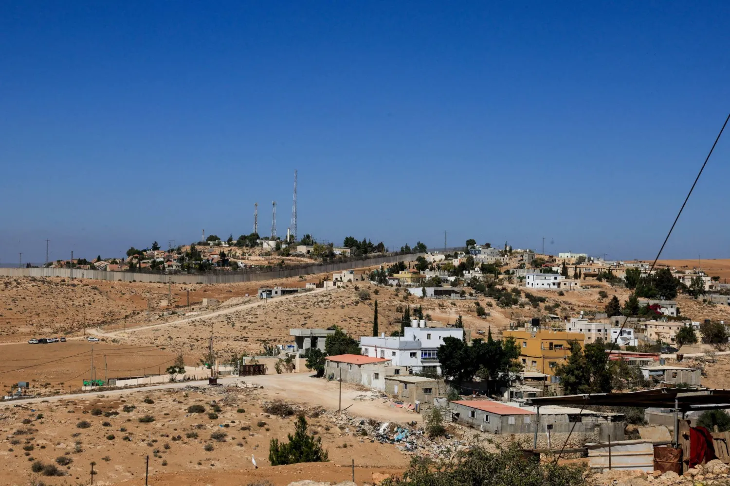 جدار فاصل بين قرية الرمادين والمستوطنة الإسرائيلية إشكولوت (رويترز)