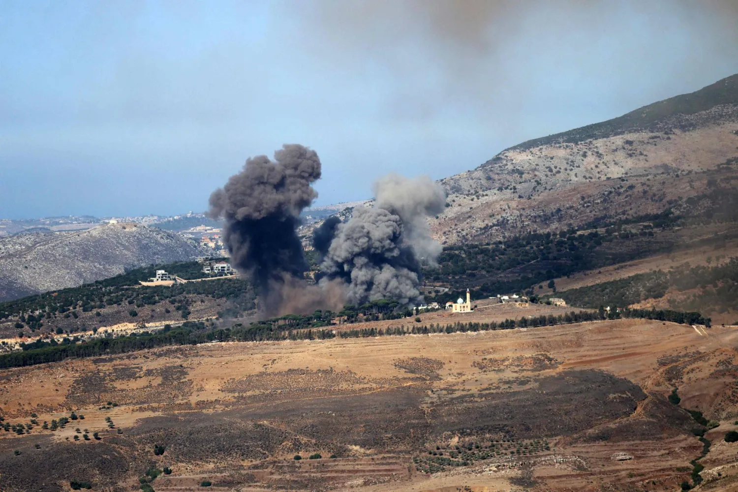 الدخان يتصاعد جراء غارات إسرائيلية استهدفت تلال الجرمق المحيطة ببلدة العيشية مسقط رأس الرئيس عون (أ.ف.ب)