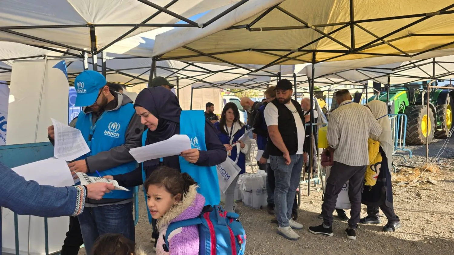 موظفون في الأمم المتحدة ورجال أمن لبنانيون يدققون في أوراق السوريين العائدين (الشرق الأوسط)