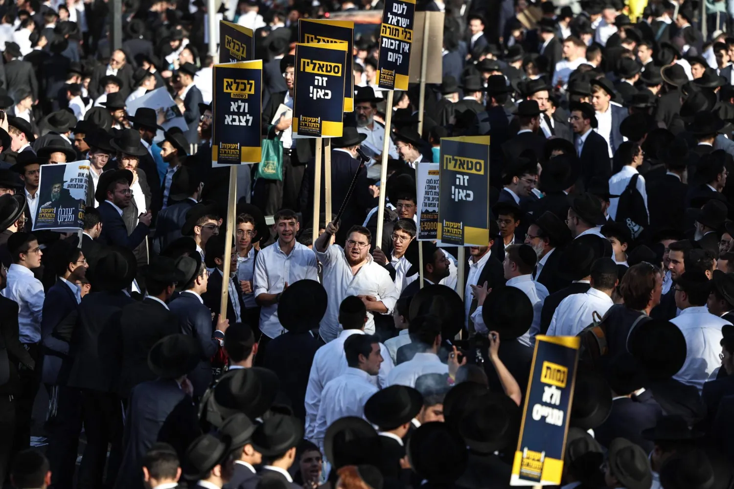 يهود حريديم يحملون لافتات خلال احتجاج ضد التجنيد بالجيش الإسرائيلي في القدس 30 أكتوبر 2025 (أ.ف.ب)