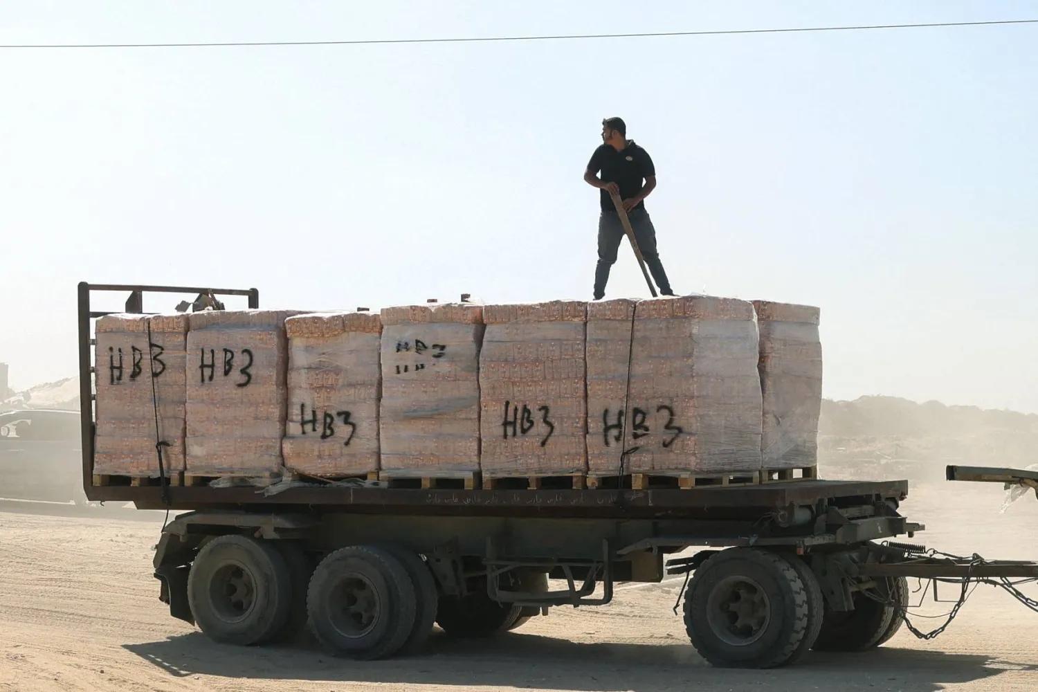 رجل فلسطيني يقف فوق شاحنة مساعدات في قطاع غزة (أ.ف.ب)