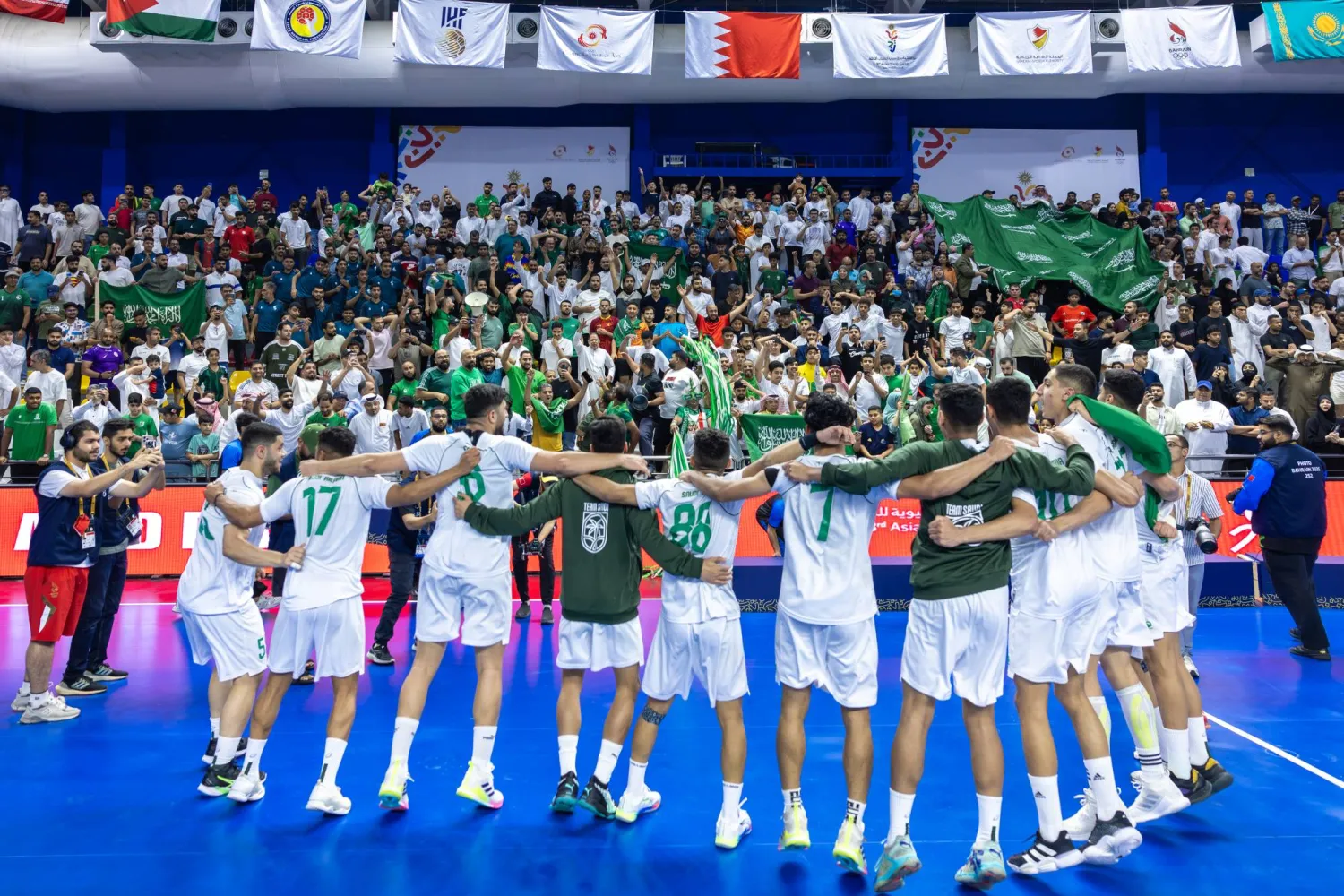 لاعبو المنتخب السعودي لليد يحتفلون مع جماهيرهم بالإنجاز (الشرق الأوسط)