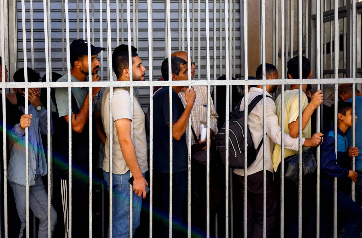 الناس يقفون في طوابير أمام «بنك فلسطين» وسط نقص في السيولة النقدية في النصيرات وسط قطاع غزة... 27 أكتوبر 2025 (رويترز)